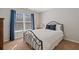 Well-lit bedroom with decorative iron bed, blue curtains, and neutral walls at 96 Grand Ave, Suwanee, GA 30024