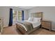 Comfortable bedroom featuring a window, a bed with storage drawers, and two nightstands at 96 Grand Ave, Suwanee, GA 30024