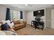 Comfortable bedroom with a large window, brown couch, and desk suitable for an office at 96 Grand Ave, Suwanee, GA 30024