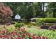 Landscaped community entrance with a pond, waterfall, and colorful flower beds, welcoming residents and guests at 96 Grand Ave, Suwanee, GA 30024