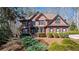 Stately brick home with manicured landscaping and mature trees on a sunny day at 96 Grand Ave, Suwanee, GA 30024