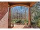 Charming front porch with brick columns, decorative planters, and a view of the wooded front yard at 96 Grand Ave, Suwanee, GA 30024