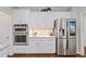 Kitchen boasting stainless steel appliances, double oven, and pristine white cabinetry at 96 Grand Ave, Suwanee, GA 30024