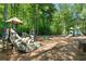 Community playground with slides, climbing structures, and swings surrounded by trees and natural mulch at 96 Grand Ave, Suwanee, GA 30024