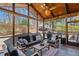 Relax in this screened porch with comfortable seating, a ceiling fan, and views of the wooded backyard at 96 Grand Ave, Suwanee, GA 30024