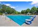 Large community swimming pool featuring lap lanes, lounge seating, and a lifeguard stand under a blue sky at 96 Grand Ave, Suwanee, GA 30024