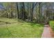 Lush green backyard with brick path offers serene natural beauty at 620 Oakstone Way, Roswell, GA 30075