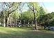 Green front yard with mature trees provides a welcoming and shady entrance to the property at 620 Oakstone Way, Roswell, GA 30075
