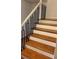 Staircase with wooden treads, white risers, and black metal railings at 620 Oakstone Way, Roswell, GA 30075