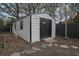 Exterior view of a metal storage shed with double doors, a window, and a ladder leaning against the side at 97 Grayson New Hope Rd, Grayson, GA 30017