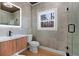 Modern bathroom with a floating vanity, walk-in shower, and window at 1337 Fairfield Dr, Lilburn, GA 30047