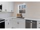 Kitchen features white cabinets, a farmhouse sink, and wood floors at 1337 Fairfield Dr, Lilburn, GA 30047