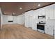 Open kitchen with white cabinets, stainless steel appliances, and light wood floors at 1337 Fairfield Dr, Lilburn, GA 30047