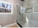 Elegant shower with glass enclosure and herringbone tile floor at 1337 Fairfield Dr, Lilburn, GA 30047
