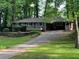 Charming one-story brick home with a front deck, mature trees, and a long driveway at 4876 Velva Nw Way, Lilburn, GA 30047