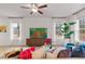 Bright living room featuring stylish decor, a ceiling fan, and large windows providing ample natural light at 223 Sanctuary Dr, Mcdonough, GA 30253