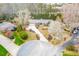 Aerial view of a well-maintained home with a lush lawn, blooming trees, and a circular driveway at 1195 Fielding Way, Marietta, GA 30068
