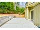 Concrete back patio area with sliding glass door, wooden retaining wall, and view of green landscaping at 1195 Fielding Way, Marietta, GA 30068