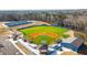 Aerial view of a pristine baseball field featuring a well-maintained green, covered dugouts, and batting cages at 1195 Fielding Way, Marietta, GA 30068
