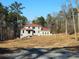 View of two-story home with red roof in construction phase on a large lot at 515 Penny Ln, Loganville, GA 30052