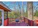 Back wooden porch featuring an outdoor grill and lush trees surrounding the house at 731 Willow Ridge Dr, Marietta, GA 30068
