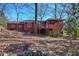 Exterior view of a red two-story home featuring a deck and fire pit in the backyard at 731 Willow Ridge Dr, Marietta, GA 30068