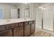 Bathroom featuring double sinks, undermount sinks, tile floors, and glass-door shower at 4311 Portsbrook Ave, Snellville, GA 30039