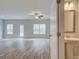 Open-concept living area with neutral walls, modern ceiling fan, wood flooring, and adjacent half-bath at 4311 Portsbrook Ave, Snellville, GA 30039