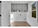 Bright laundry room with light gray cabinets and wood floors at 4571 Deep Creek Dr, Sugar Hill, GA 30518