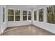 Bright sunroom with wall-to-wall windows and hardwood floors at 4571 Deep Creek Dr, Sugar Hill, GA 30518