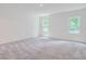 Spacious bedroom with soft carpet, light walls, and natural light from two windows at 213 Cottontail Ln, Villa Rica, GA 30180