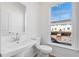 Well-lit powder room with modern pedestal sink and large window at 242 Lytham Se Dr, Mableton, GA 30126