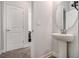 Simple half bathroom with pedestal sink and a round mirror at 6292 Hickory Lane Cir, Union City, GA 30291