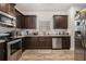 Modern kitchen with dark cabinets, stainless steel appliances, and wood-look floors at 6292 Hickory Lane Cir, Union City, GA 30291