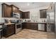 Modern kitchen with dark cabinets, stainless steel appliances, and wood-look floors at 6292 Hickory Lane Cir, Union City, GA 30291