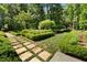 Landscaped garden with stone path, lush greenery, and box hedges at 4345 Mount Paran Nw Pkwy, Atlanta, GA 30327