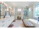 Elegant bathroom with double vanity, soaking tub, and frameless shower at 4851 Hanalei Holw, Suwanee, GA 30024