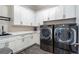 Bright laundry room with white cabinets, quartz countertops, and modern LG washer and dryer at 4851 Hanalei Holw, Suwanee, GA 30024