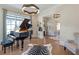 Bright music room with grand piano, guitar, and hardwood floors at 4851 Hanalei Holw, Suwanee, GA 30024