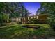 Expansive backyard at dusk, featuring a brick home with a screened porch and lush greenery beneath a twilight sky at 2144 Kennesaw Due West Nw Rd, Kennesaw, GA 30152