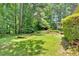 Lush green backyard with mature trees and partial view of home at 2144 Kennesaw Due West Nw Rd, Kennesaw, GA 30152