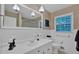 Bathroom with white tile, large mirror, and traditional fixtures at 2144 Kennesaw Due West Nw Rd, Kennesaw, GA 30152