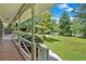 Inviting covered front porch with white railings overlooking a lush, green lawn and mature trees at 2144 Kennesaw Due West Nw Rd, Kennesaw, GA 30152