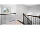 Bright upstairs hall with iron railings and window at 423 Payne Rd, Woodstock, GA 30188