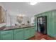 Kitchen view showcasing an island with granite counters, green cabinets, and stainless steel refrigerator at 3461 Valley View Dr, Marietta, GA 30068