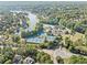 Aerial view of a community with tennis courts, a pool, and recreational area surrounded by trees and homes at 2960 Millwater Xing, Dacula, GA 30019