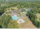 Overhead view of a community pool, playground, and tennis courts amidst a lush green setting at 2960 Millwater Xing, Dacula, GA 30019