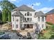 Elegant home exterior showcasing a pristine patio, balcony, and manicured lawn at 2960 Millwater Xing, Dacula, GA 30019