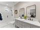 Well-lit bathroom featuring a double sink vanity, modern fixtures, and a tiled shower with a glass door at 2960 Millwater Xing, Dacula, GA 30019