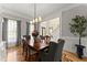 Elegant dining room featuring hardwood floors, wainscoting, and a modern chandelier at 2960 Millwater Xing, Dacula, GA 30019